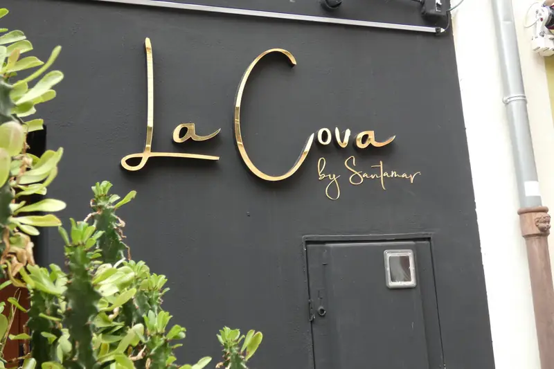 Rótulo dorado de La Cova by Santamaria en la fachada del restaurante, en La Font d'en Carròs